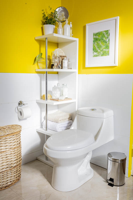 Baño amarillo con repisa con objetos decorativos