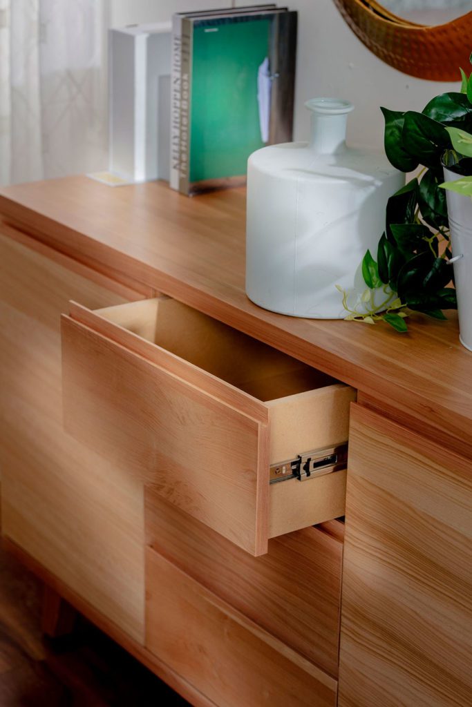 Detalle de mueble de madera y cajón abierto.