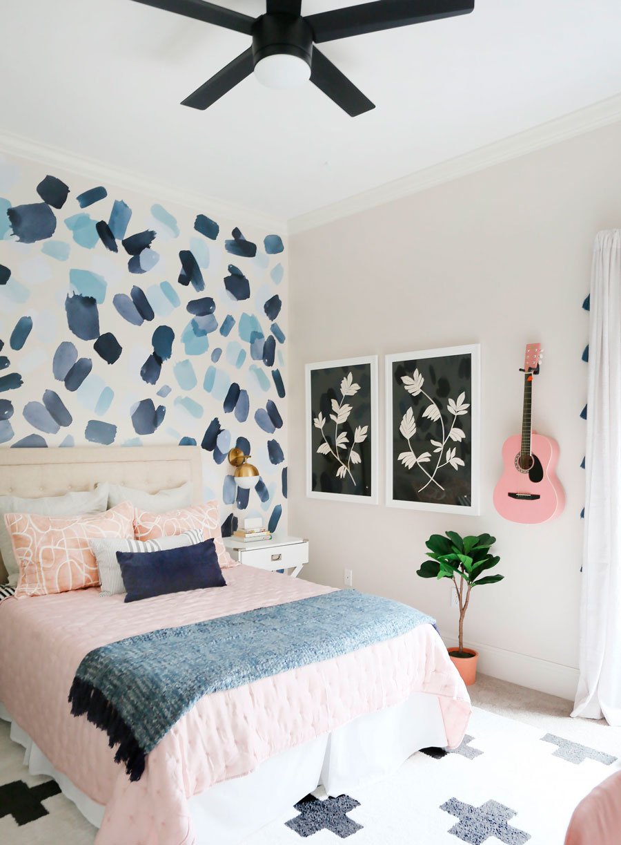 Papel mural con formas en tonalidades azules. Ubicado en el cabecero de la cama.