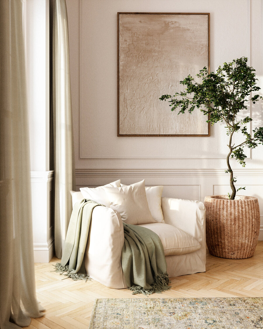 Parte de una sala de estar con un sillón blanco con una manta verde sobre él. A su costado hay una gran planta dentro de un macetero café. En la pared del fondo hay un cuadro en color crema.